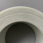 An image of a roll of glass fiber reinforced high density polyethylene (PE) tape viewed from the side, showcasing its neatly arranged lateral surface.